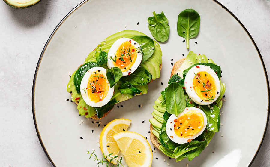 Toast met avocado, spinazie en een gekookt eitje